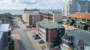 Une zone urbaine côtière avec des immeubles à plusieurs étages, un parking et une vue sur la mer.