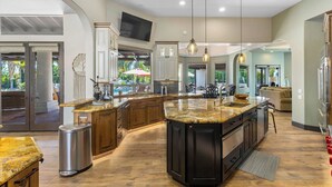 A spacious kitchen with a large island, wooden cabinets, and a built-in oven. - Saguaro Estate - .3 Acre Private Paradise (La Quinta)
