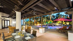 An indoor dining area with a view of an outdoor pool and tropical landscaping. - Saguaro Estate - .3 Acre Private Paradise (La Quinta)