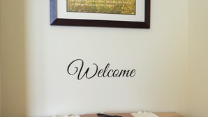 A framed landscape photo with a "Welcome" sign above a wooden table with a notebook and pen. - Quiet Home Close to Sedona (Rimrock)