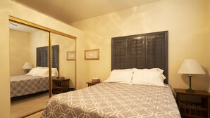A hotel room with a large bed, a bedside table, a nightstand, a mirror, and a lamp. - Quiet Home Close to Sedona (Rimrock)