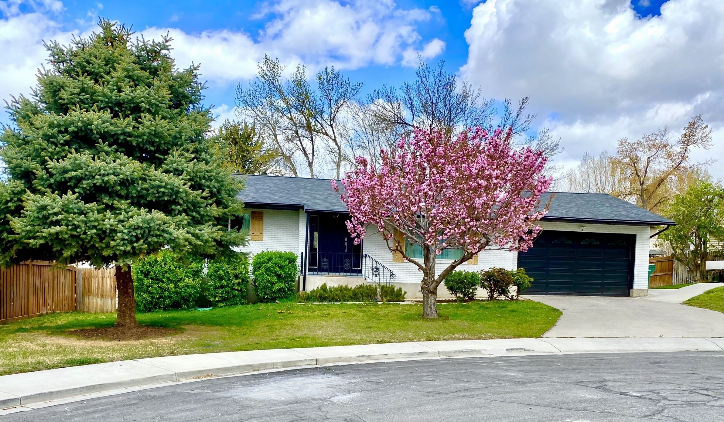 Ein Einfamilienhaus mit Garage, Auffahrt und gepflegtem Rasen.