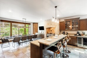 A modern kitchen with a large island, stone backsplash, and wooden cabinets. - Mountain View Rooftop Deck + Hot Tub, walk to Main st. Park City Ultimate Loft 4 (Park City)