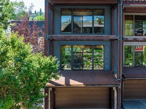 A modern two-story house with large windows, a garage, and a tree in the foreground. - Mountain View Rooftop Deck + Hot Tub, walk to Main st. Park City Ultimate Loft 4 (Park City)