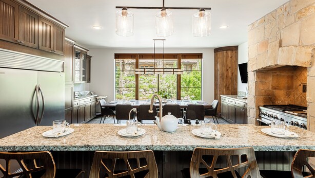 A modern kitchen with granite countertops, stainless steel appliances, and a large island with seating.