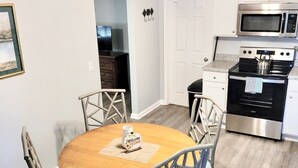 Una cucina moderna con isola centrale, un tavolo da pranzo con sedie e una ventola a soffitto.