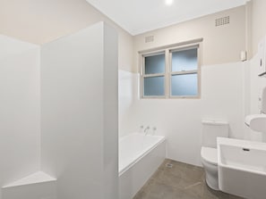 Enjoy a refreshing shower or soak in the standalone bathtub, surrounded by clean lines and natural light.