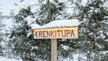 A wooden sign with the name 'RENKITUPA' in capital letters, surrounded by snow-covered trees.