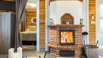 A cozy room with a brick fireplace, a bed, and a bathroom visible through an open door.