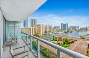 A balcony with a view of a river, high-rise buildings, and a marina. - Beachwalk Vacation (Hallandale Beach)