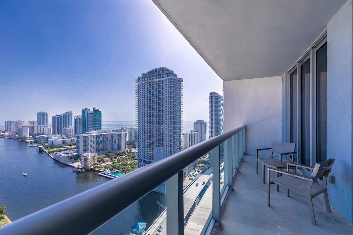 Un balcón con vistas a un horizonte urbano y una masa de agua.