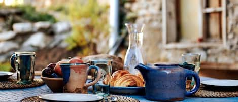 A table set with various glassware, a blue pitcher, and pastries, suggesting a breakfast setting.