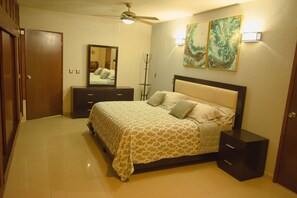 A bedroom with a bed, dresser, and a ceiling fan. - Private house, pool, bbq and jacuzzi!! (Mazatlán)