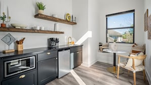Una cocina moderna con armarios negros, horno integrado y ventana con vistas al exterior.