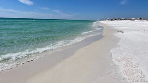 Uma praia com águas turquesa cristalinas e areia branca.