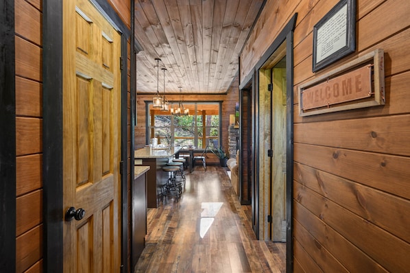Un intérieur en bois agrémenté d’une enseigne « BIENVENUE », d’un espace bar et d’une vue dégagée grâce à de grandes fenêtres.