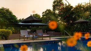 Una piscina con sillas de descanso y sombrillas.
