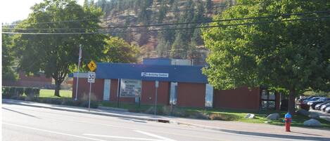 A building with a sign indicating an activity center, a speed limit sign, and a fire hydrant.