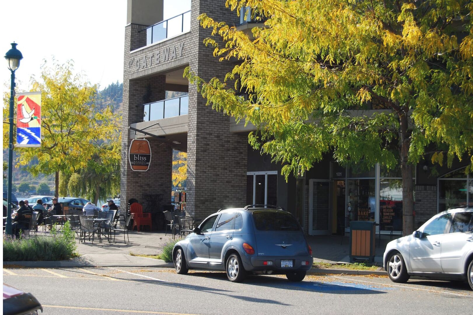 Un edificio con un letrero que dice "Bliss" y un estacionamiento con coches.
