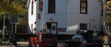 A white building with a sign for the Peachland Museum.