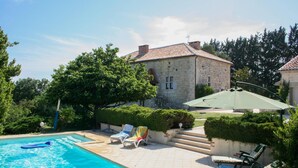 A swimming pool with lounge chairs and a stone building in the background. - Gîte with swimming pool and park garden (Saint Maurin)