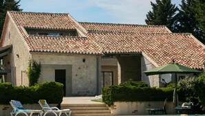 A two-story building with a tiled roof, a swimming pool, and outdoor seating. - Gîte with swimming pool and park garden (Saint Maurin)