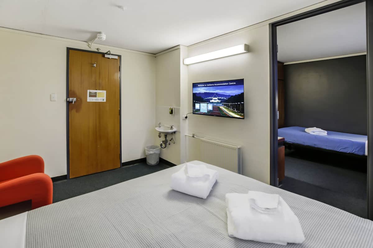Ein Hotelzimmer mit einem Bett, einem Schreibtisch, einem Stuhl, einem Fernseher und einem Badezimmer.