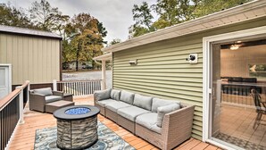 Une terrasse couverte avec un canapé, des chaises et un foyer.
