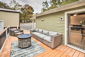 Relax in this inviting outdoor space with a comfortable sofa, round table, and patterned rug.