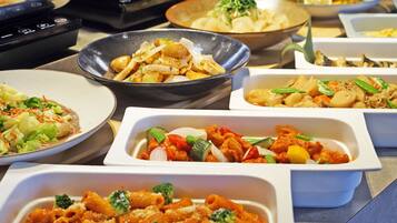 A buffet with various dishes including pasta, vegetables, and meat.
