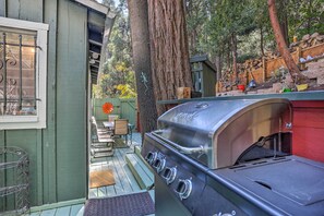 A backyard with a barbecue grill, wooden deck, and a dining area with outdoor furniture. - 1 Mi to Lake Gregory: Boho Crestline Cabin (Crestline)