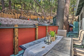 An outdoor seating area with a table and chairs, a wooden bench, and a potted plant. - 1 Mi to Lake Gregory: Boho Crestline Cabin (Crestline)