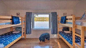 Una habitación con literas, una ventana con cortinas y vistas a un paisaje nevado.