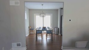 A spacious living area with a dining table and chairs, a sofa, and a hallway leading to another room. - Downtown Silver Spring Ranch home! (Silver Spring)