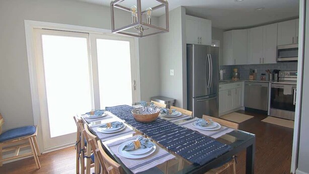 A modern kitchen with stainless steel appliances, a dining area with a glass table, and a large window providing natural light. - Downtown Silver Spring Ranch home! (Silver Spring)