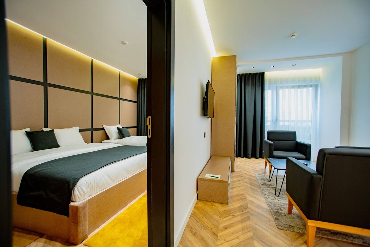 A hotel room with a bed, a desk, a chair, and a TV.