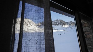 Une vue sur un paysage montagneux enneigé, visible depuis une fenêtre.