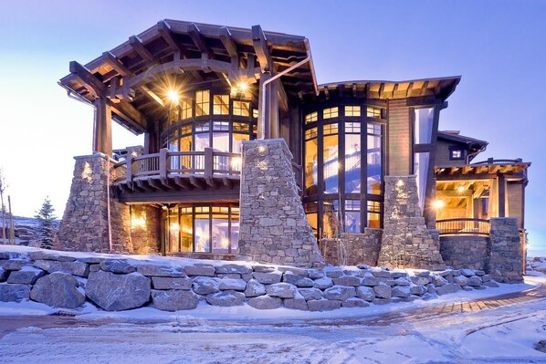 Experience the inviting atmosphere of this multi-level lodge with a curved roofline and large windows.