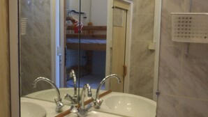 Ein Badezimmer mit Waschbecken, Spiegel und Holzschränken.