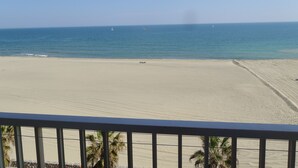 Ein Strand mit freiem Blick auf das Meer und entfernte Segelboote.