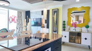 A modern kitchen with a central island, built-in oven, and a large mirror above the countertop. - Beachfront  w/ View •Luxury •Smart TV • Gym (Juan Dolio)