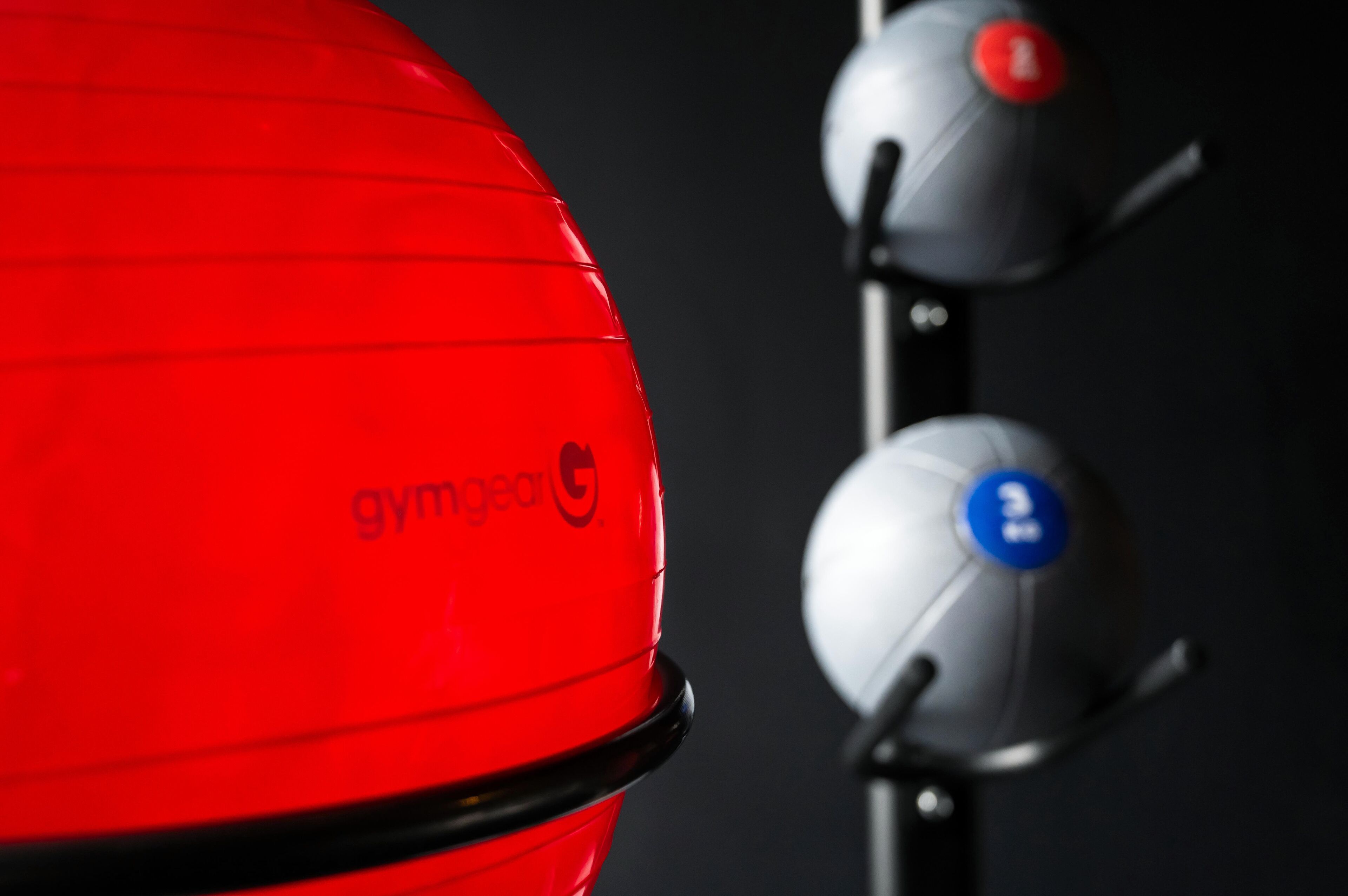 A red gym equipment with the brand name 'gymgear' and a black handlebar.