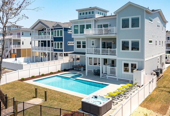 A multi-story residential building with a swimming pool, outdoor seating, and a hot tub. - Pier, Pool, Sunsets • Luxe Soundfront Retreat (Corolla)