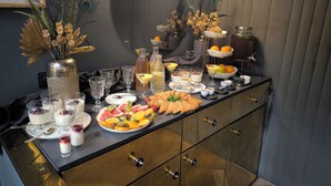 A buffet setup with various food items, drinks, and decorative elements. - Leo Boutique Rooms - Adults Only (Budapest)