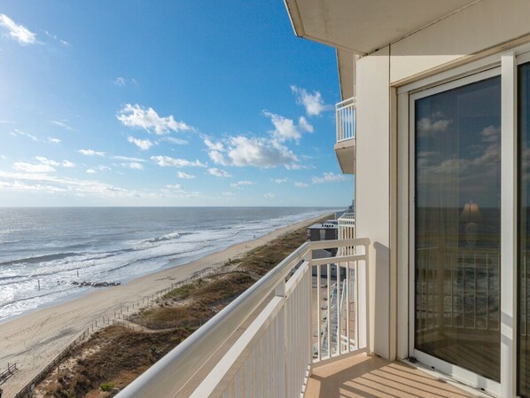 Ein Balkon mit Blick auf Strand und Meer.