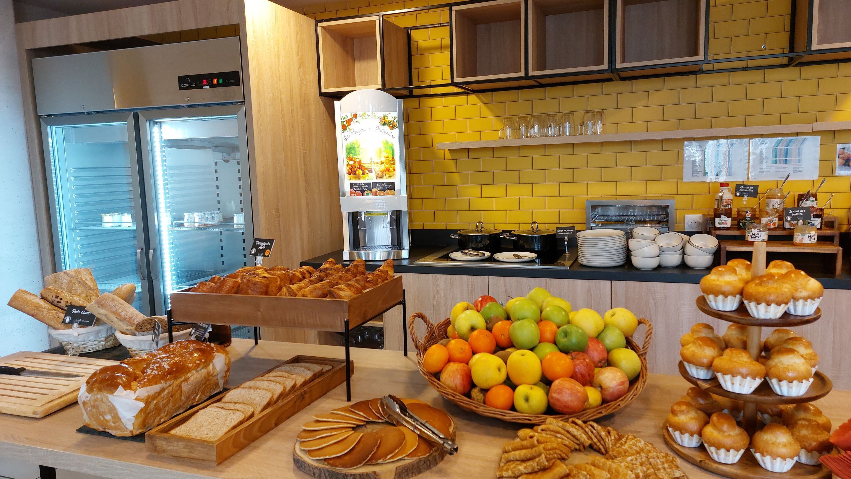 A buffet with various food items including bread, pastries, and fruits.