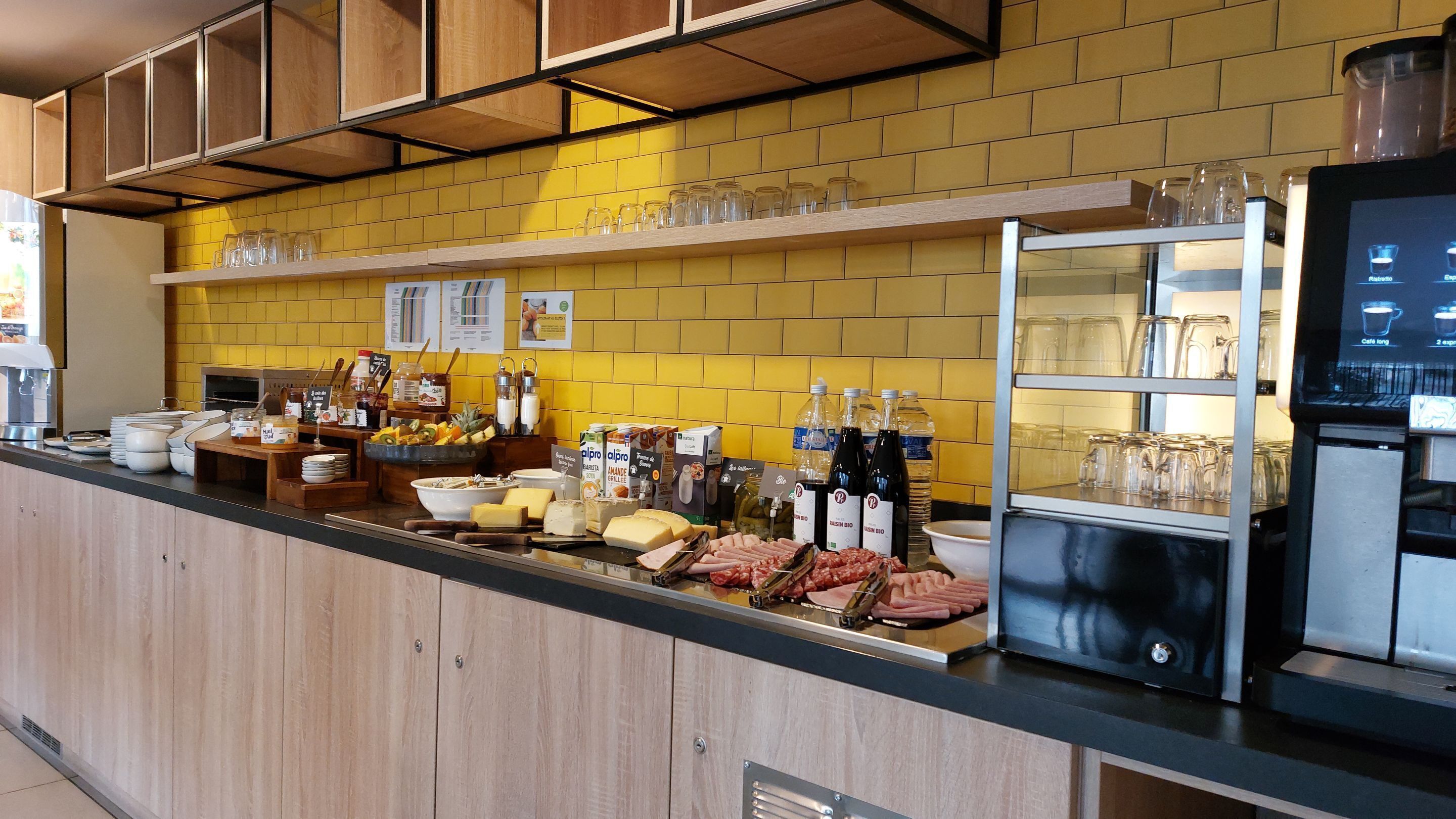 Un comptoir-buffet proposant divers aliments et boissons, une machine à café et une vitrine réfrigérée.