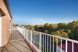 A balcony with a metal railing overlooking a parking lot and trees. - Appart Hotel Odalys City Centre Compans Caffarelli (Toulouse)