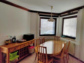 Enjoy meals in this cozy dining area with a table and chairs, microwave, and natural light pouring in through the windows.