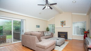 A living room with a sectional sofa, a coffee table, and a fireplace.